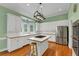 Bright kitchen features white cabinets, stainless appliances, hardwood floors, and central island with cooktop at , Suwanee, GA 30024