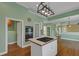 Modern kitchen with hardwood floors, central island, white cabinets, stainless ovens, and view into other rooms at , Suwanee, GA 30024