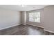 Well-lit bedroom with wood-look flooring, a large window, and neutral walls at 310 Ashigan St, Union City, GA 30291
