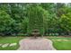 Landscaped backyard featuring mature trees, lush green lawn, stone walkway, and a decorative fountain at 5119 Greythorne Ln, Marietta, GA 30068