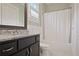 Bathroom with dark vanity, granite countertop, shower with white curtain, and patterned tile flooring at 5119 Greythorne Ln, Marietta, GA 30068