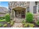 Stone front porch featuring a stone archway, large wooden door, and decorative lighting for a grand entrance at 5119 Greythorne Ln, Marietta, GA 30068