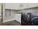 Well-lit laundry room featuring a washer and dryer, ample storage, and a sleek countertop at 5119 Greythorne Ln, Marietta, GA 30068