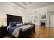Spacious primary bedroom featuring a tray ceiling, fireplace, built-in shelves, and hardwood floors at 5119 Greythorne Ln, Marietta, GA 30068