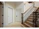 A wooden staircase with iron railings leads to the second floor, complemented by neutral-toned walls and tiled floors at 5119 Greythorne Ln, Marietta, GA 30068