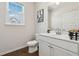 Bright bathroom featuring a white vanity, framed mirror, toilet, and a window providing natural light at 2237 Foley Park St, Snellville, GA 30078