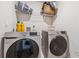 Laundry room featuring front load washer and dryer with wire rack and cleaning supplies above at 2237 Foley Park St, Snellville, GA 30078