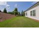 Well-maintained backyard featuring lush green lawn, mature trees, and a wooden fence at 5320 Coltman Dr, Cumming, GA 30028
