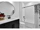 Stylish bathroom with modern black and white design, featuring a sleek vanity, round mirror, and subway tiled shower at 5320 Coltman Dr, Cumming, GA 30028