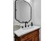 Bathroom vanity with an ornate framed mirror, a white countertop, and a wood grain cabinet at 5320 Coltman Dr, Cumming, GA 30028