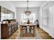 Formal dining room featuring wood floors, a modern chandelier, and large windows for natural light at 5320 Coltman Dr, Cumming, GA 30028