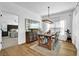 Bright dining room showcasing hardwood floors, modern chandelier, and an open view to an adjacent bedroom at 5320 Coltman Dr, Cumming, GA 30028