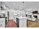 Open kitchen view with white cabinets, stainless appliances, an island with seating, and open to living space at 5320 Coltman Dr, Cumming, GA 30028