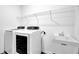 Functional laundry room equipped with modern washer and dryer, a utility sink, and plenty of storage space at 5320 Coltman Dr, Cumming, GA 30028
