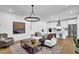 Bright living room featuring modern lighting, wood floors, and an open concept to the kitchen at 5320 Coltman Dr, Cumming, GA 30028