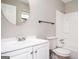 Bathroom showcasing modern fixtures, white vanity, round mirror, toilet, and bath shower combo at 5474 Post Road Pass, Stone Mountain, GA 30088