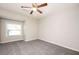 Cozy bedroom with neutral carpet, a ceiling fan, and a window for natural light at 5474 Post Road Pass, Stone Mountain, GA 30088