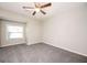 Bright bedroom features neutral walls, gray carpet, ceiling fan and natural light from window at 5474 Post Road Pass, Stone Mountain, GA 30088