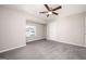 Bedroom featuring neutral walls, gray carpet, ceiling fan, natural light from window, and closet at 5474 Post Road Pass, Stone Mountain, GA 30088