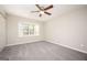 Bedroom featuring neutral walls, gray carpet, natural light from window, and closet at 5474 Post Road Pass, Stone Mountain, GA 30088