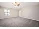 Large bedroom featuring neutral walls, gray carpet, ceiling fan, natural light from window, and closet at 5474 Post Road Pass, Stone Mountain, GA 30088