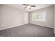Cozy bedroom featuring a ceiling fan, natural light, and comfortable carpet flooring at 5474 Post Road Pass, Stone Mountain, GA 30088