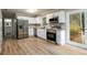 Modern kitchen with stainless steel appliances, white cabinets, and hardwood flooring, perfect for cooking at 60 Valley Rd, Covington, GA 30016