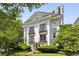 Elegant white building featuring balconies, framed by lush greenery and a well-manicured lawn at 1072 Piedmont Ne Ave # 101, Atlanta, GA 30309