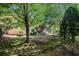 Backyard with grass area, rock border and mature shade trees at 1600 Heritage Trl, Roswell, GA 30075