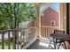 Outdoor balcony features seating and a view of neighboring homes and lush trees at 1600 Heritage Trl, Roswell, GA 30075