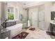 Bright bathroom featuring a modern tub, glass shower, and marble floors at 1600 Heritage Trl, Roswell, GA 30075