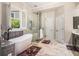 Bright bathroom featuring a large freestanding tub next to a shower with glass enclosure and tile surround at 1600 Heritage Trl, Roswell, GA 30075