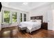 Spacious bedroom featuring hardwood floors, accent wall, large windows with shutters, and neutral decor at 1600 Heritage Trl, Roswell, GA 30075