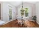 Bright dining area with hardwood floors, modern light fixture, and windows overlooking the backyard at 1600 Heritage Trl, Roswell, GA 30075