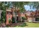 Well-maintained brick home with a front porch, balcony, and lush green landscaping in a suburban setting at 1600 Heritage Trl, Roswell, GA 30075