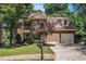 Charming two-story brick home with a well-manicured lawn, two-car garage, and beautiful mature trees at 1600 Heritage Trl, Roswell, GA 30075