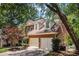 Traditional brick home featuring a two-car garage and mature trees at 1600 Heritage Trl, Roswell, GA 30075