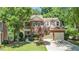 Charming two-story brick home with attached two-car garage and manicured front lawn at 1600 Heritage Trl, Roswell, GA 30075