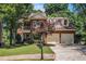 Beautiful two-story brick home with well-manicured lawn, two-car garage, and lovely trees at 1600 Heritage Trl, Roswell, GA 30075