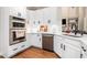 Modern kitchen features stainless appliances, white cabinets, stone countertops, tile backsplash, and hardwood floors at 1600 Heritage Trl, Roswell, GA 30075