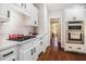 Updated kitchen features stainless appliances, white cabinets, stone countertops, tile backsplash, and hardwood floors at 1600 Heritage Trl, Roswell, GA 30075