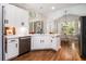 Bright eat-in kitchen features white cabinets, stainless appliances, hardwood floors, and a view of the backyard at 1600 Heritage Trl, Roswell, GA 30075