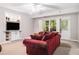 Cozy living room features built-in shelves, a red sofa and large windows for ample natural light at 1600 Heritage Trl, Roswell, GA 30075