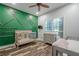 Charming Bedroom with wooden cribs, stylish green accent wall, and ceiling fan enhancing comfort at 188 Cooper Creek Dr, Dallas, GA 30157