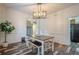 Bright dining room features modern chandelier, table with benches, and view to kitchen area at 188 Cooper Creek Dr, Dallas, GA 30157