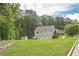 Side view of a well-maintained house with a spacious lawn, surrounded by lush trees, and a three-car garage at 188 Cooper Creek Dr, Dallas, GA 30157