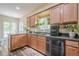 Bright kitchen featuring wood cabinets, dark countertops, and abundant greenery adds natural charm at 188 Cooper Creek Dr, Dallas, GA 30157