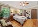 Well-lit bedroom features hardwood floors, a tray ceiling with lighting, and comfortable furnishings at 4649 Dahlia Dr, Pine Lake, GA 30072
