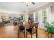 An open dining room with hardwood floors, large windows, and a dark wood table for six at 4649 Dahlia Dr, Pine Lake, GA 30072