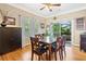 A well-lit dining room with a wooden table, six chairs, and access to an outdoor balcony at 4649 Dahlia Dr, Pine Lake, GA 30072
